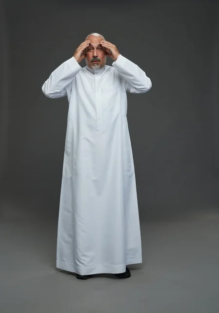 Stressed Arab Man in White Thobe on Gray Background