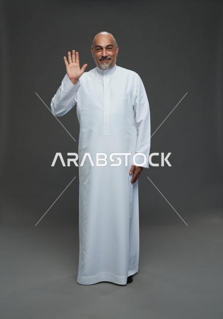 رجل عربي بالثوب الأبيض التقليدي يلوح بالتحية