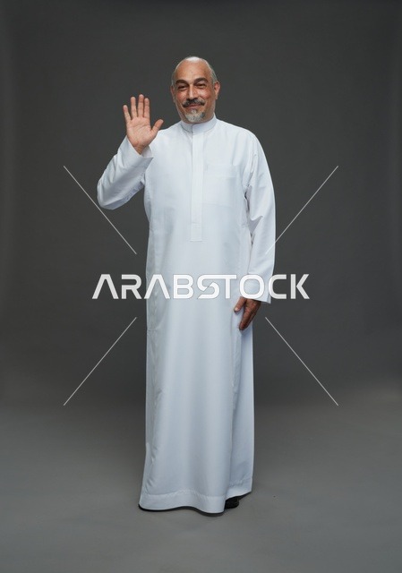 رجل سعودي مسن بالثوب الأبيض يلوح بيده في الاستوديو