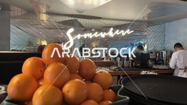 برتقال طازج داخل مطعم عصري مع لافتة نيون بيضاء مضيئة