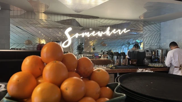 Fresh Oranges in Modern Cafe Interior with Neon Sign