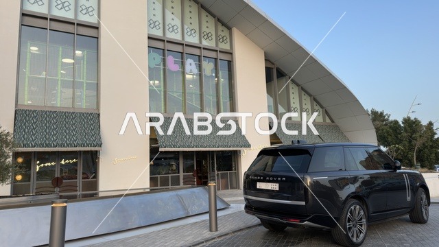 سيارة رينج روفر سوداء أمام مبنى تجاري حديث