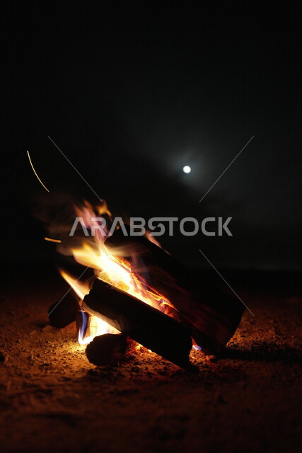 صورة لشعلة الحطب، حرق خشب الشجر، رحلات برية، أجواء شتوية، رحلة برية في صحراء المملكة العربية السعودية، جلسة بر عربية شعبية مع شعلة الحطب في صحراء السعودية، شبة نار، جمال القمر في سماء السعودية