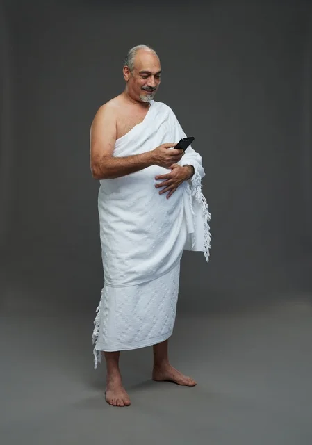 Arab Pilgrim in Ihram Using Smartphone Studio Shot