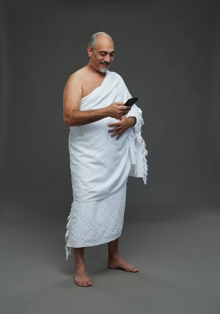 Arab Man in Ihram Clothing Using Smartphone Studio Shot