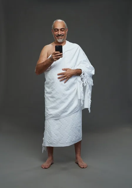 Middle Eastern Man in Ihram Using Smartphone