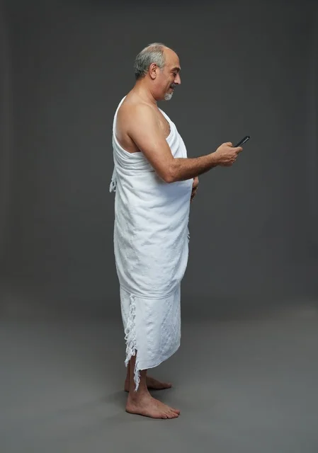 Saudi Pilgrim in Ihram Using Smartphone Studio Shot