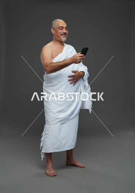 Saudi Pilgrim in Ihram Using Smartphone in Studio