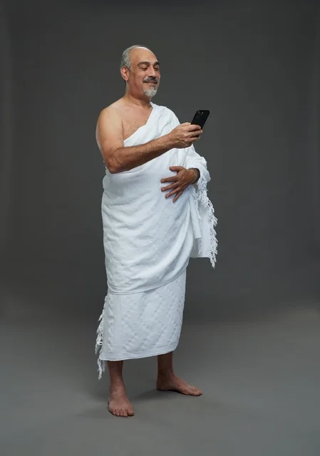 Senior Saudi Man in Ihram Using Smartphone Studio
