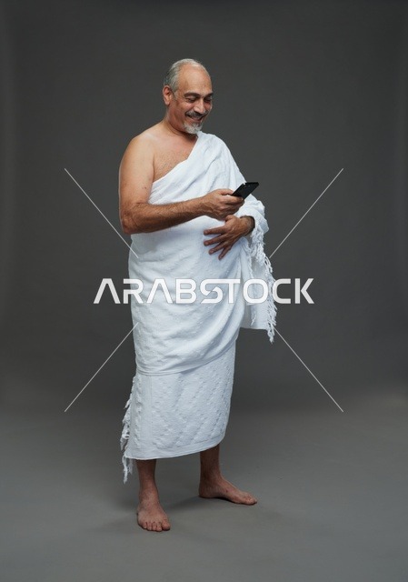 Arab Man in Ihram Using Smartphone Studio Portrait