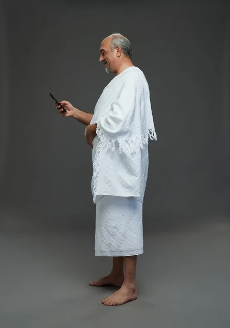 Saudi Pilgrim in Ihram Using Smartphone Studio Shot