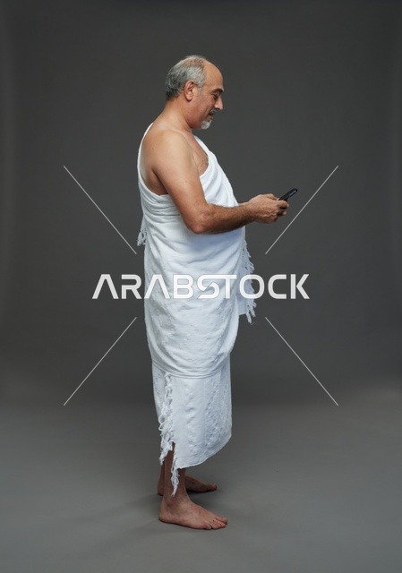 Arab Pilgrim in Ihram Using Smartphone Studio