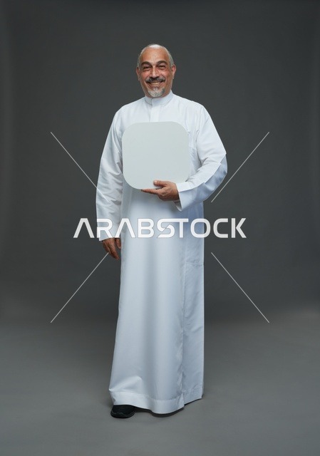 رجل عربي مسن يرتدي الثوب السعودي يحمل لوحة بيضاء فارغة