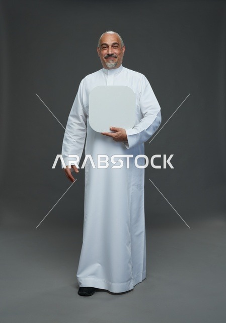 رجل سعودي بالثوب التقليدي يحمل لوحة بيضاء فارغة