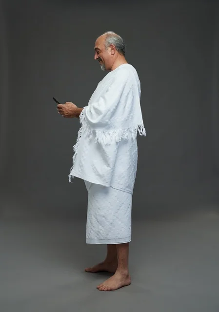 Saudi Pilgrim in Ihram Using Smartphone Studio Portrait