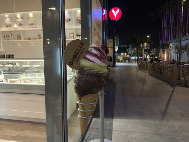 مجسم آيس كريم ضخم خارج واجهة متجر جيلاتو في الليل