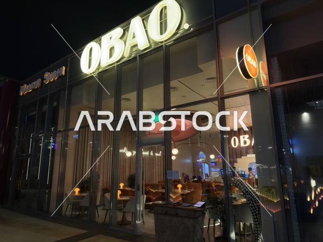 واجهة مطعم أوباو الزجاجية الخارجية مع إضاءة ليلية حديثة