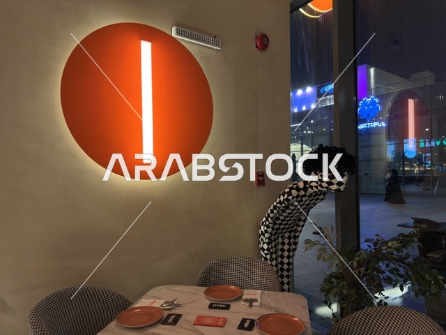 تصميم داخلي لمطعم حديث مع إضاءة برتقالية وديكور