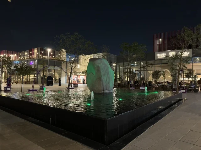 Modern Outdoor Plaza Fountain with Green Lighting at Night
