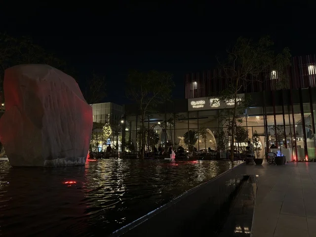 ساحة خارجية حديثة ليلاً مع حوض مائي