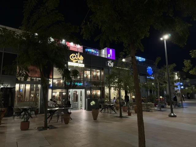 ساحة تجارية خارجية ومطاعم ومقاهي في منظر ليلي