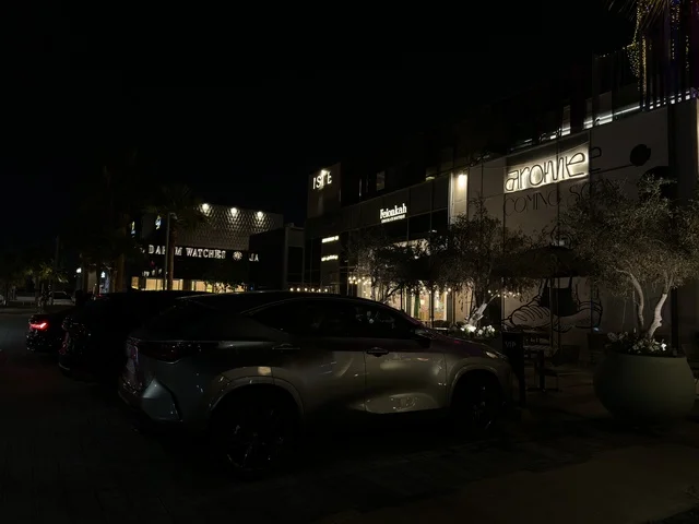 واجهات متاجر حديثة وشارع تجاري في منطقة حضرية ليلاً