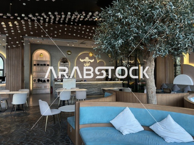 التصميم الداخلي لمقهى حديث مع جلسات زرقاء وشجرة
