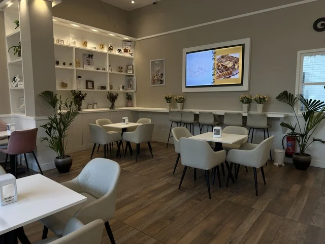 تصميم داخلي لمقهى حديث مع طاولات بيضاء وجلسات