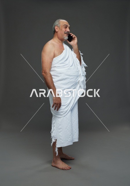 رجل سعودي بملابس الإحرام يتحدث عبر الهاتف