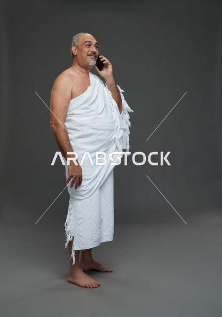 رجل سعودي بملابس الإحرام يتحدث بالهاتف