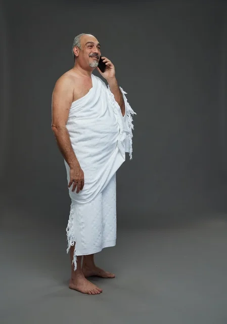 رجل سعودي بملابس الإحرام يتحدث بالهاتف