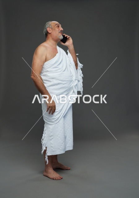 رجل سعودي بملابس الإحرام يتحدث عبر الجوال في استوديو