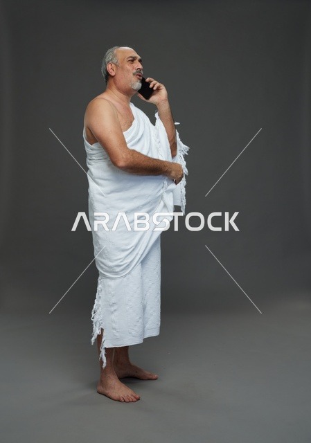 رجل سعودي بملابس الإحرام يتحدث بالهاتف