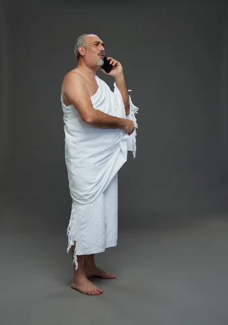 رجل سعودي بملابس الإحرام يتحدث بالهاتف