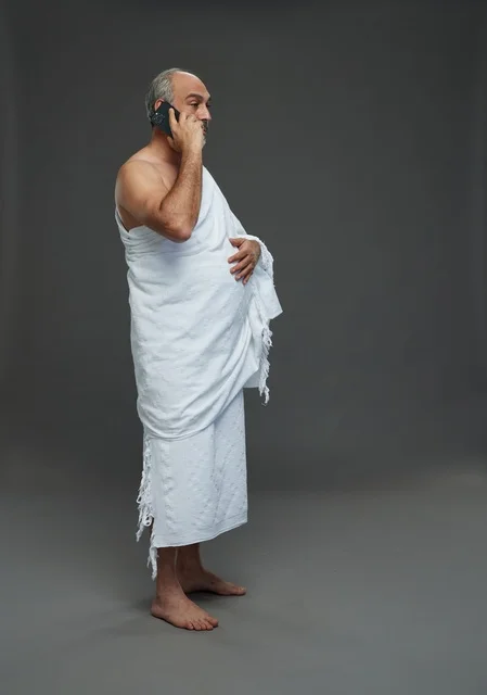 رجل سعودي بملابس الإحرام يتحدث عبر الهاتف تصوير استوديو