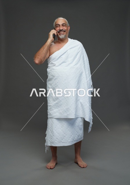رجل سعودي بملابس الإحرام يتحدث بالهاتف