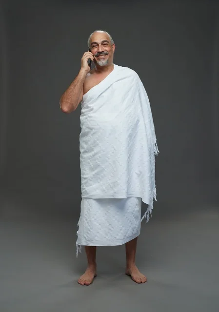 Saudi Man in Ihram Talking on Smartphone Studio Shot