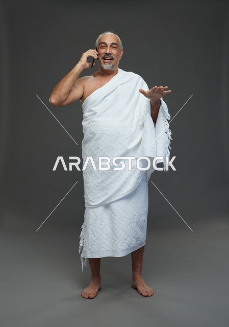 رجل سعودي بملابس الإحرام يتحدث بالهاتف