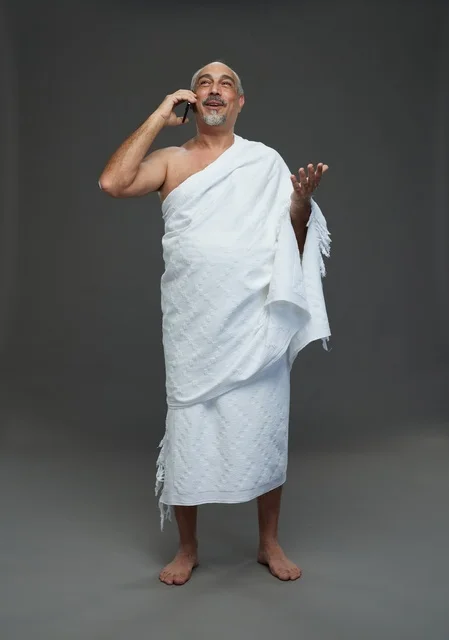 Saudi Man in Ihram Talking on Smartphone Studio Shot