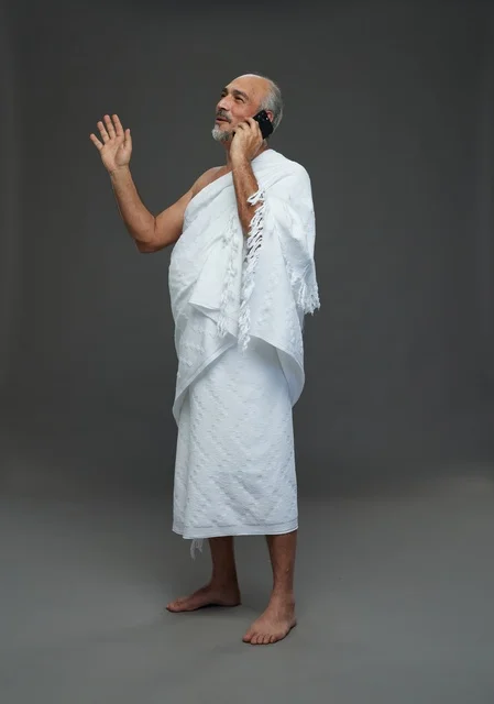 رجل سعودي بملابس الإحرام يتحدث بالهاتف في استوديو رجل سعودي بملابس الإحرام يتحدث بالهاتف في استوديو