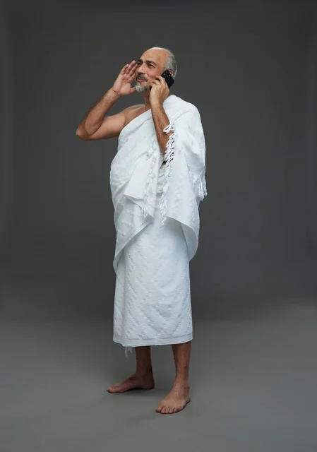 رجل سعودي بملابس الإحرام يتحدث بالهاتف