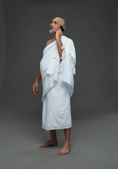 Saudi Man in Ihram Talking on Smartphone Studio Shot