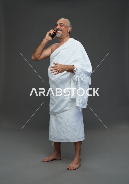 رجل سعودي بملابس الإحرام يتحدث بالهاتف