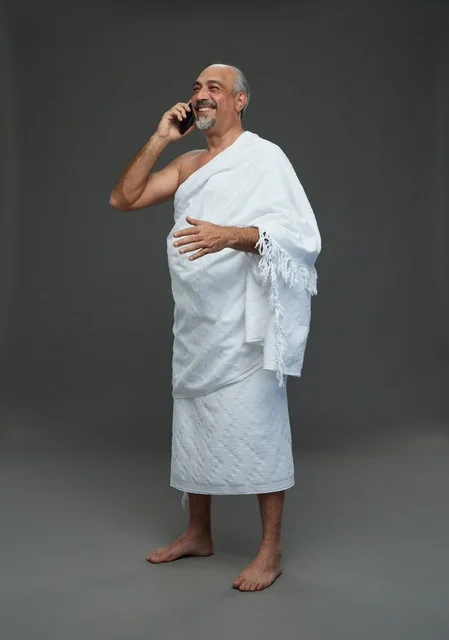 رجل سعودي بملابس الإحرام يتحدث بالهاتف