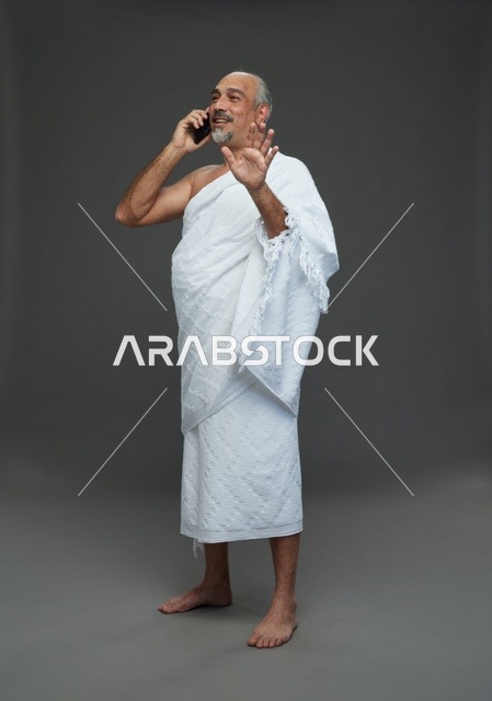رجل سعودي بملابس الإحرام يتحدث بالهاتف في استوديو