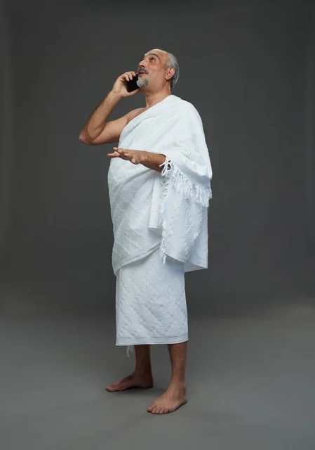 رجل سعودي بملابس الإحرام يتحدث بالهاتف