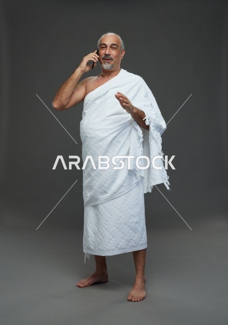 رجل سعودي بملابس الإحرام يتحدث بالجوال