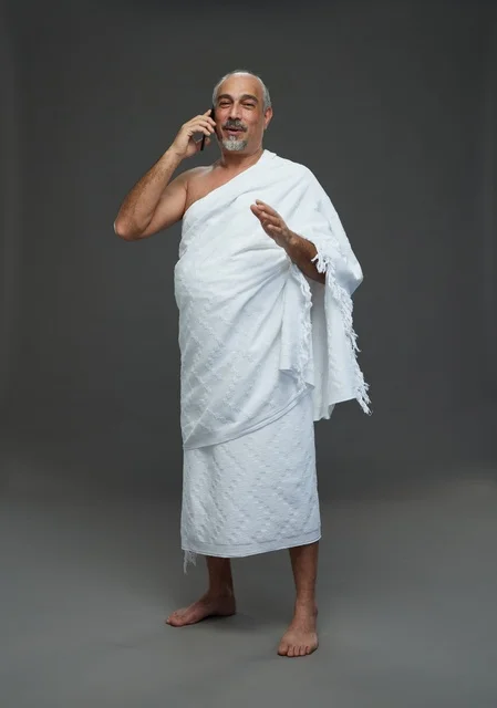 رجل سعودي بملابس الإحرام يتحدث بالجوال