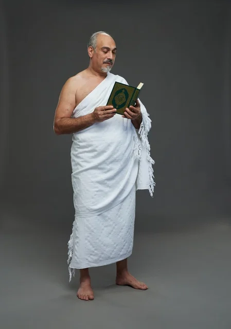 Saudi Man in Ihram Reading Holy Quran in Studio