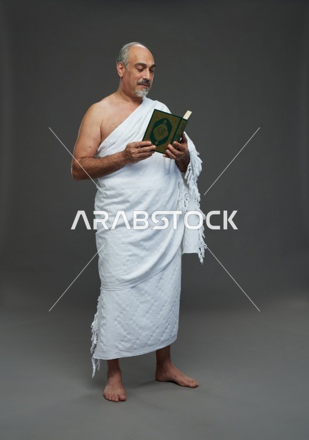 رجل سعودي بملابس الإحرام يقرأ القرآن الكريم